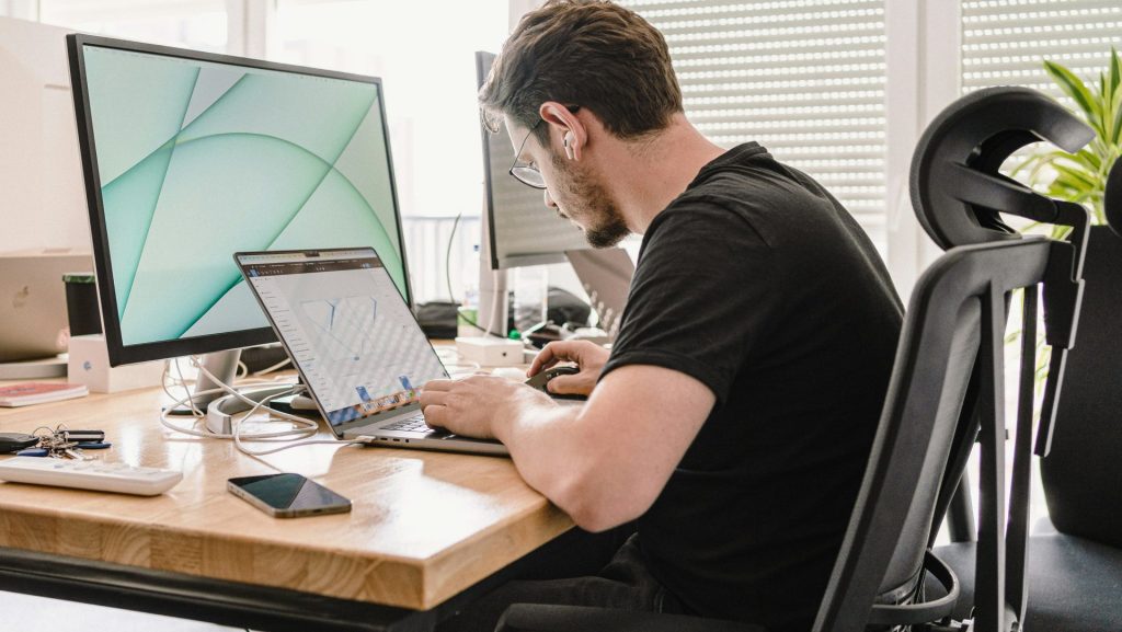 a man sitting at a desk working on a computer