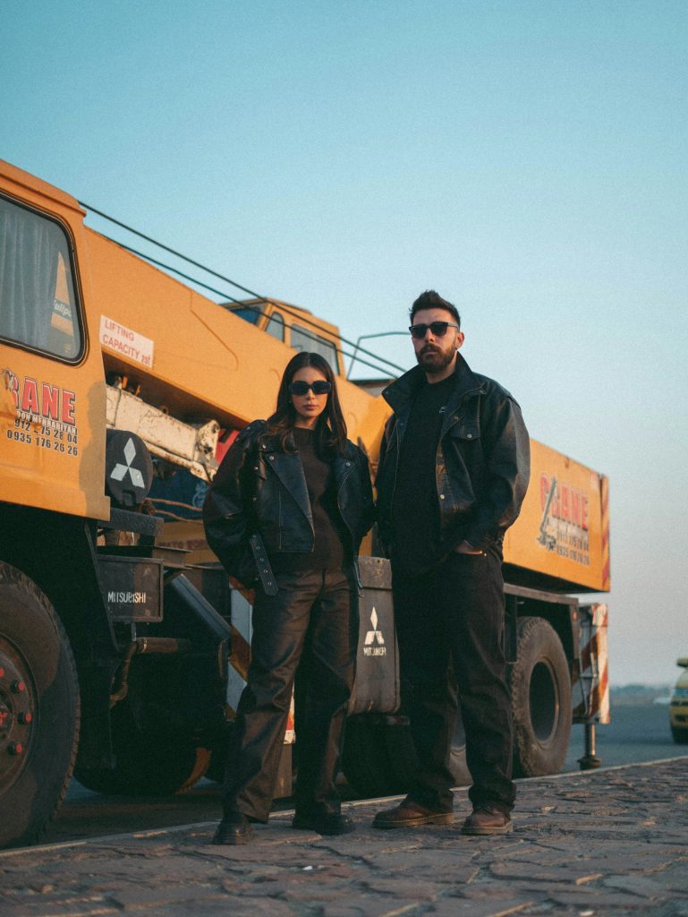 A man and a woman standing next to a yellow truck